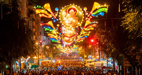 Personnes fêtant dans une rue illuminée par des lampions décorée avec des guirlandes lors de la fête des saints populaires à Lisbonne au Portugal