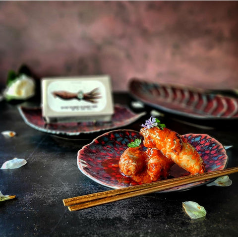 calamars en sauce ragoût sur une assiette bleue et rouge avec baguettes chinoises